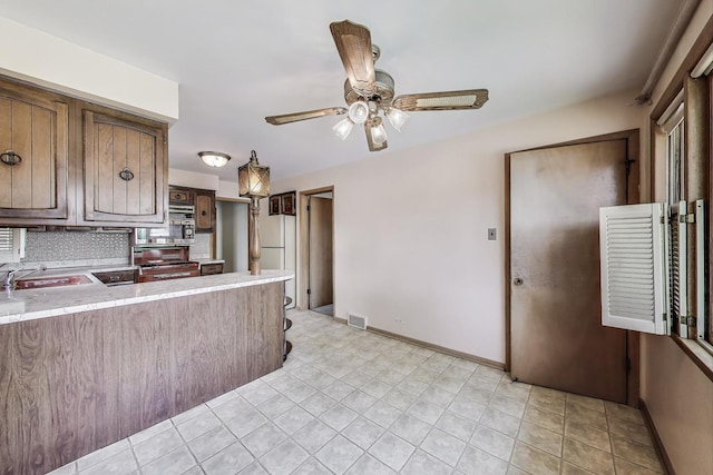 1927 Herbert Ave, Berkeley, IL 60163 - kitchen with light countertops, stove, freestanding refrigerator, decorative backsplash, and ceiling fan