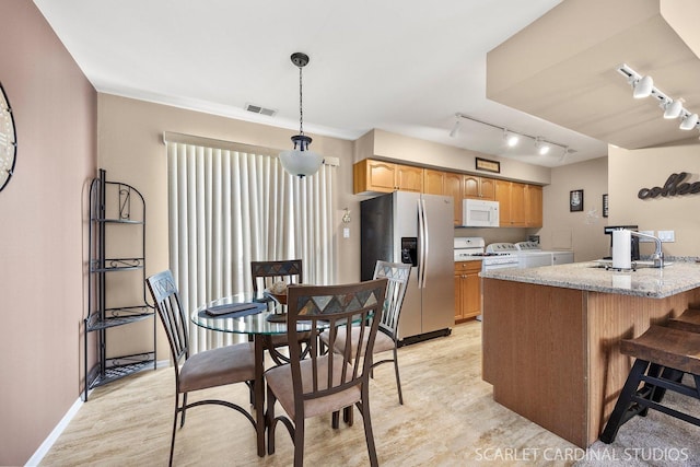 1641 Cornell Dr, Hoffman Estates, IL 60169 - kitchen with white appliances, washing machine and dryer, track lighting, a peninsula, and light stone counters