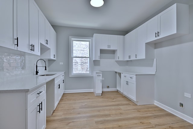 8004 S Ada St, Chicago, IL 60620 - kitchen with light wood finished floors, white cabinetry, tasteful backsplash, and light countertops