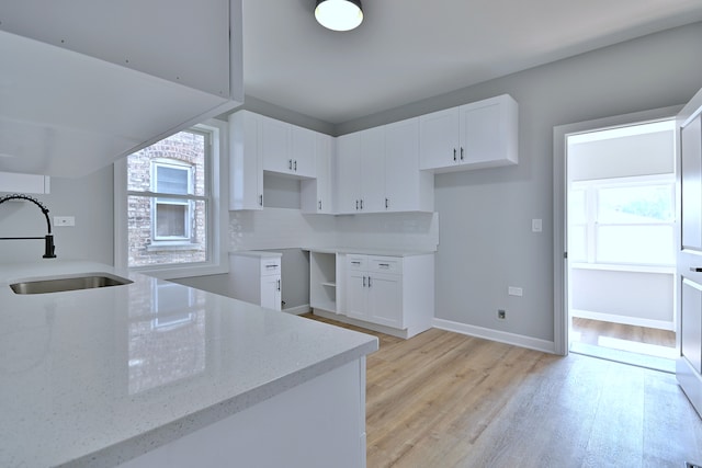 8004 S Ada St, Chicago, IL 60620 - kitchen featuring light stone counters, light wood-style flooring, and white cabinets