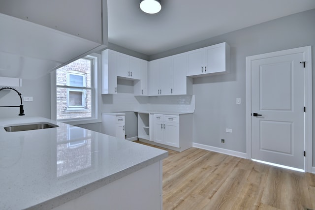 8004 S Ada St, Chicago, IL 60620 - kitchen with light stone countertops, light wood-style floors, and white cabinets