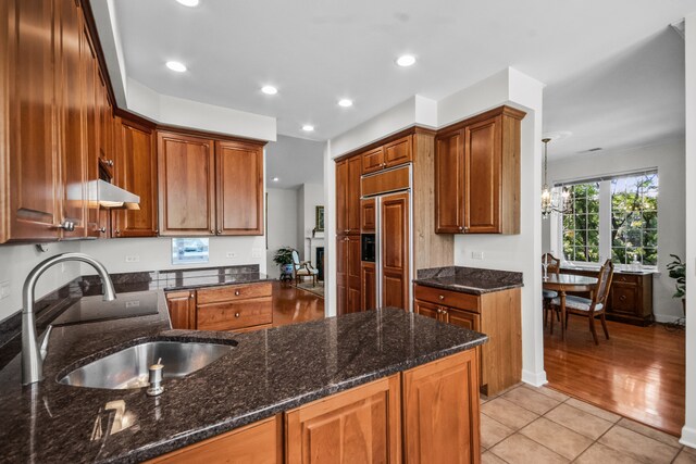 2660 Summit Dr Unit 302, Glenview, IL 60025 - kitchen with under cabinet range hood, a chandelier, brown cabinetry, recessed lighting, and light tile patterned floors