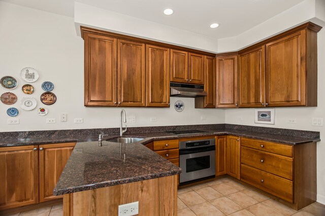 2660 Summit Dr Unit 302, Glenview, IL 60025 - kitchen featuring stainless steel oven, under cabinet range hood, light tile patterned floors, a peninsula, and dark stone countertops