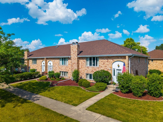 15317 S 73rd Ave Unit 8, Orland Park, IL 60462 - raised ranch featuring a chimney, brick siding, a front lawn, and roof with shingles