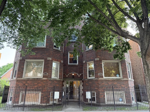 6938 S Dorchester Ave Unit 2, Chicago, IL 60637 - view of front of house with brick siding, a fenced front yard, and a gate