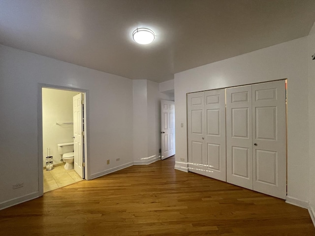 6938 S Dorchester Ave Unit 2, Chicago, IL 60637 - unfurnished bedroom featuring a closet, wood finished floors, and connected bathroom