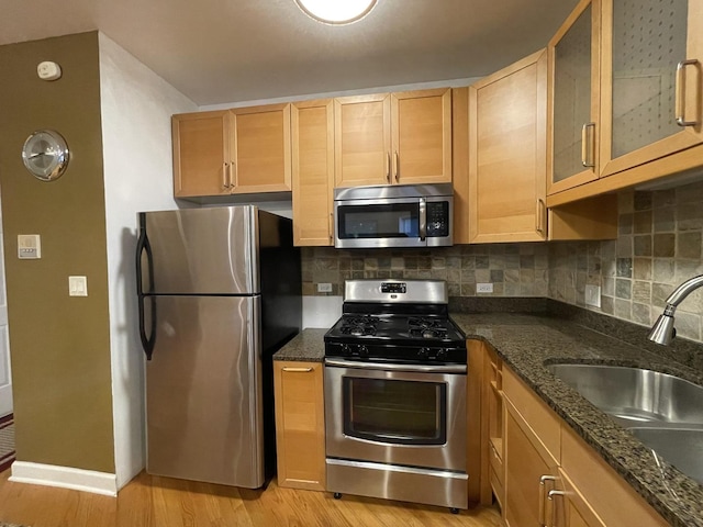 6938 S Dorchester Ave Unit 2, Chicago, IL 60637 - kitchen with stainless steel appliances, light wood finished floors, decorative backsplash, dark stone counters, and glass insert cabinets