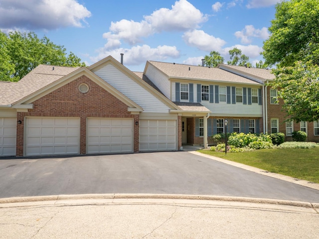 1400 Ashton Ct Unit B1, Wheeling, IL 60090 - view of front of house with brick siding, an attached garage, asphalt driveway, a front lawn, and a shingled roof
