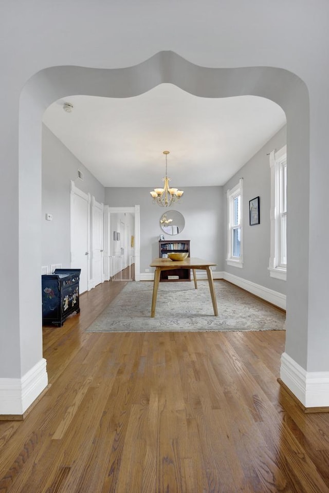 1848 W Cermak Rd Unit 3, Chicago, IL 60608 - dining area with arched walkways, wood finished floors, and a chandelier