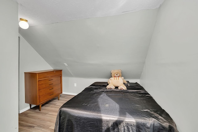 1819 Il Route 176, Crystal Lake, IL 60014 - bedroom with light wood-style floors, lofted ceiling, and a textured ceiling