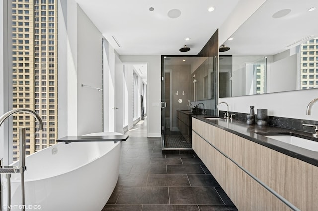 403 N Wabash Ave Unit 17C, Chicago, IL 60611 - bathroom featuring double vanity, a freestanding bath, a shower stall, tile patterned floors, and recessed lighting