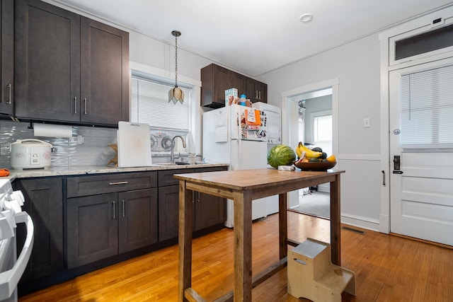 5043 W Argyle St, Chicago, IL 60630 - kitchen featuring freestanding refrigerator, stove, light wood-style flooring, dark brown cabinetry, and backsplash
