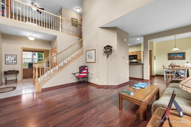 937 Emerald Dr, Pingree Grove, IL 60140 - living room featuring stairs, wood finished floors, a high ceiling, and ceiling fan