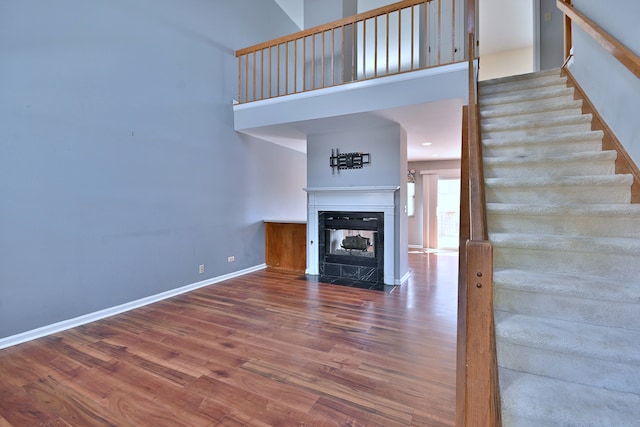 633 Ascot Ln, Streamwood, IL 60107 - unfurnished living room with wood finished floors, stairs, a multi sided fireplace, and a high ceiling
