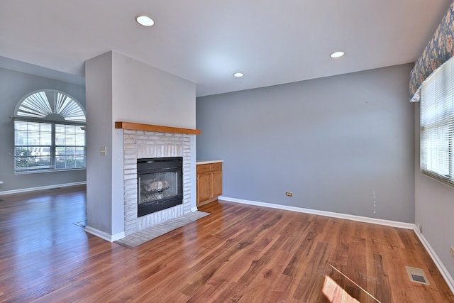 633 Ascot Ln, Streamwood, IL 60107 - unfurnished living room featuring wood finished floors, a brick fireplace, and recessed lighting