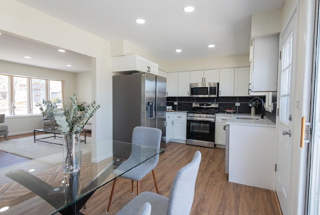 507 Wingate Dr, Schaumburg, IL 60193 - kitchen with appliances with stainless steel finishes, backsplash, wood finished floors, white cabinetry, and light countertops
