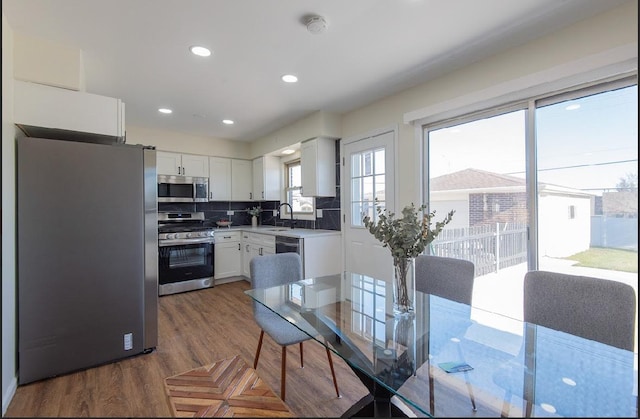 507 Wingate Dr, Schaumburg, IL 60193 - kitchen featuring stainless steel appliances, white cabinetry, backsplash, light countertops, and recessed lighting
