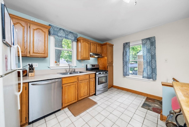 21207 Locust St, Matteson, IL 60443 - kitchen featuring appliances with stainless steel finishes, light countertops, under cabinet range hood, and brown cabinetry