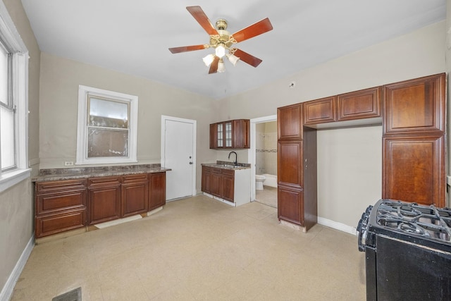 5938 S La Salle St, Chicago, IL 60621 - kitchen featuring a ceiling fan, black gas range, and brown cabinetry