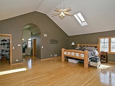 9417 W Steger Rd, Frankfort, IL 60423 - bedroom with arched walkways, lofted ceiling, light wood-style floors, and multiple windows
