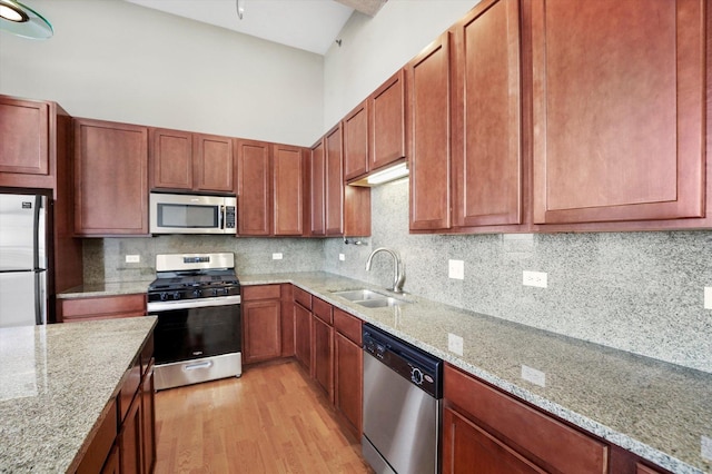 3963 W Belmont Ave Unit 613, Chicago, IL 60618 - kitchen featuring appliances with stainless steel finishes, light wood-style flooring, backsplash, and light stone counters