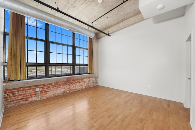 3963 W Belmont Ave Unit 613, Chicago, IL 60618 - unfurnished room featuring wood finished floors and brick wall