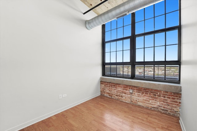 3963 W Belmont Ave Unit 613, Chicago, IL 60618 - unfurnished room with brick wall and wood finished floors