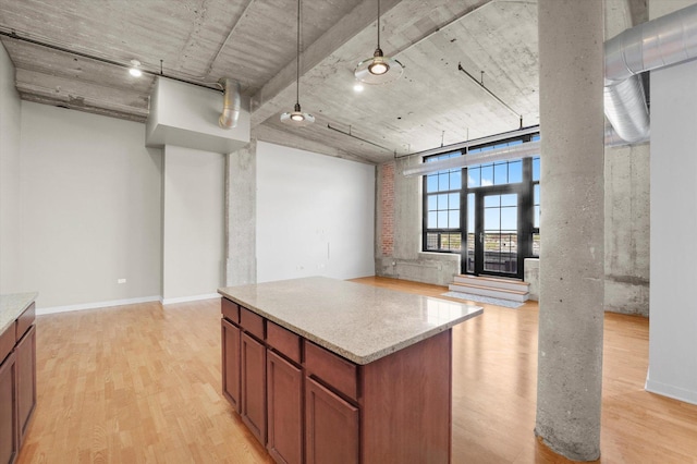 3963 W Belmont Ave Unit 613, Chicago, IL 60618 - kitchen with light wood finished floors, pendant lighting, brown cabinetry, a center island, and light stone countertops
