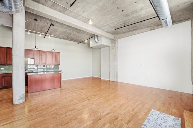 3963 W Belmont Ave Unit 613, Chicago, IL 60618 - kitchen with open floor plan, light wood-style floors, tasteful backsplash, a kitchen island, and rail lighting