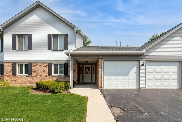 330 Memory Ln Unit 2, Westmont, IL 60559 - traditional-style house featuring an attached garage, brick siding, asphalt driveway, and a front lawn
