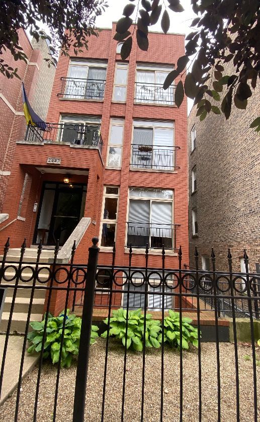 2447 W Walton St Unit 2, Chicago, IL 60622 - back of property featuring brick siding and a fenced front yard