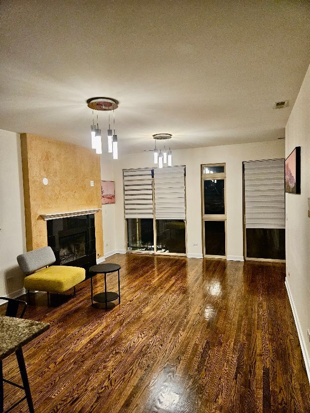 2447 W Walton St Unit 2, Chicago, IL 60622 - living area featuring a fireplace, wood finished floors, and a textured ceiling