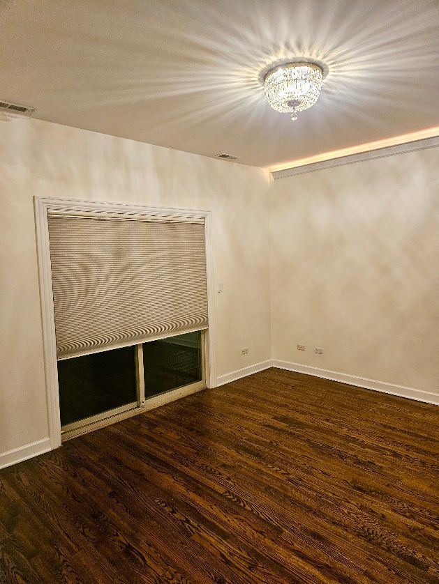 2447 W Walton St Unit 2, Chicago, IL 60622 - spare room with wood finished floors and a chandelier