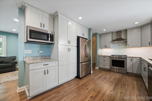 24106 W Pheasant Chase Dr, Plainfield, IL 60544 - kitchen featuring appliances with stainless steel finishes, wall chimney exhaust hood, wood finished floors, backsplash, and recessed lighting