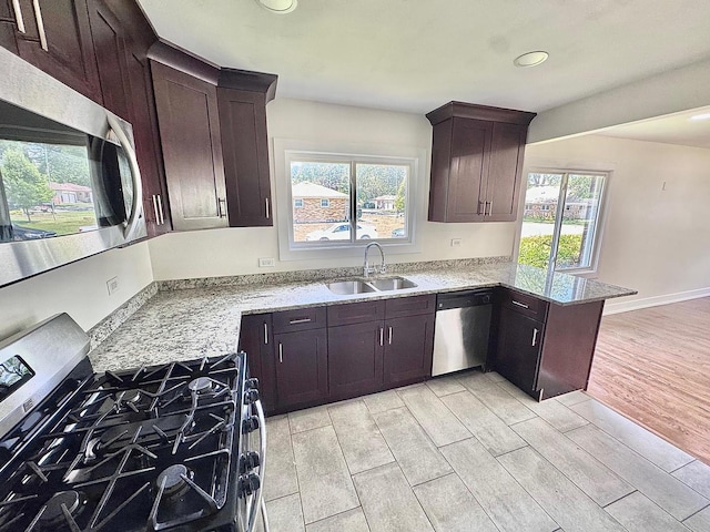 837 Wilcox Ave, Mundelein, IL 60060 - kitchen with appliances with stainless steel finishes, wood finish floors, a peninsula, light stone countertops, and recessed lighting