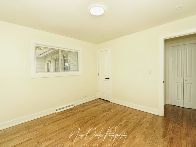 837 Wilcox Ave, Mundelein, IL 60060 - unfurnished room with wood finished floors and a baseboard heating unit