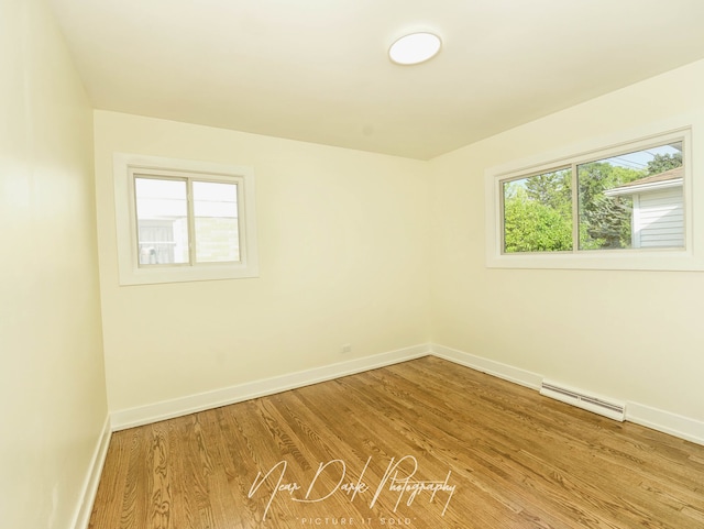 837 Wilcox Ave, Mundelein, IL 60060 - spare room featuring a baseboard radiator and wood finished floors