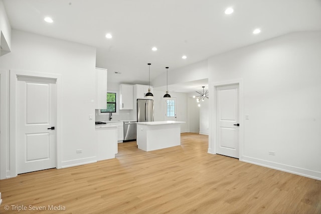 8100 Lockwood Ave, Burbank, IL 60459 - kitchen with appliances with stainless steel finishes, a center island, white cabinets, light countertops, and light wood finished floors