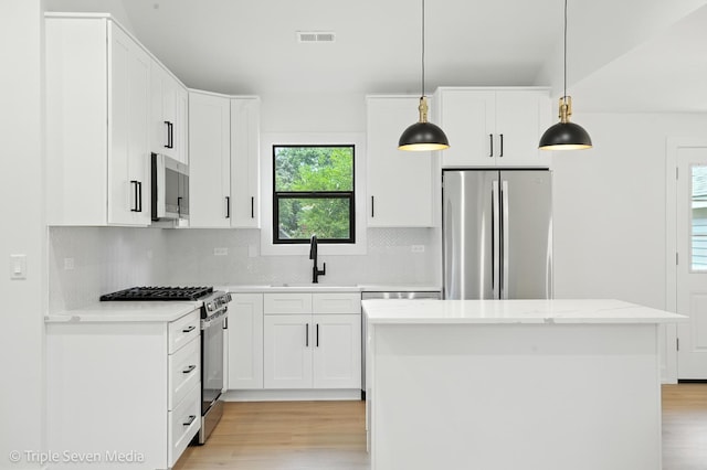 8100 Lockwood Ave, Burbank, IL 60459 - kitchen with appliances with stainless steel finishes, light wood-style floors, tasteful backsplash, and a kitchen island