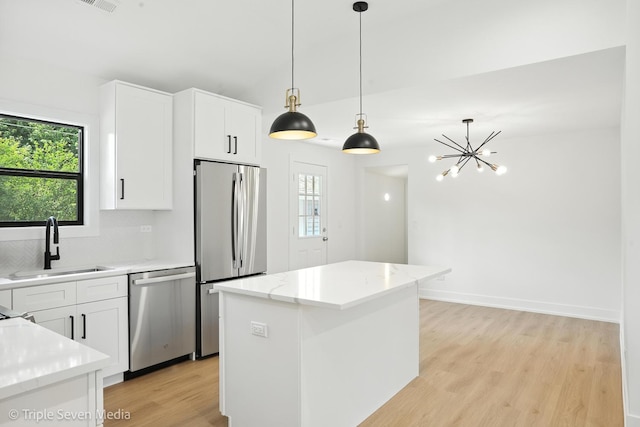8100 Lockwood Ave, Burbank, IL 60459 - kitchen featuring appliances with stainless steel finishes, healthy amount of natural light, light wood-style floors, and hanging light fixtures