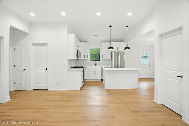 8100 Lockwood Ave, Burbank, IL 60459 - kitchen featuring appliances with stainless steel finishes, a center island, light countertops, light wood-type flooring, and recessed lighting