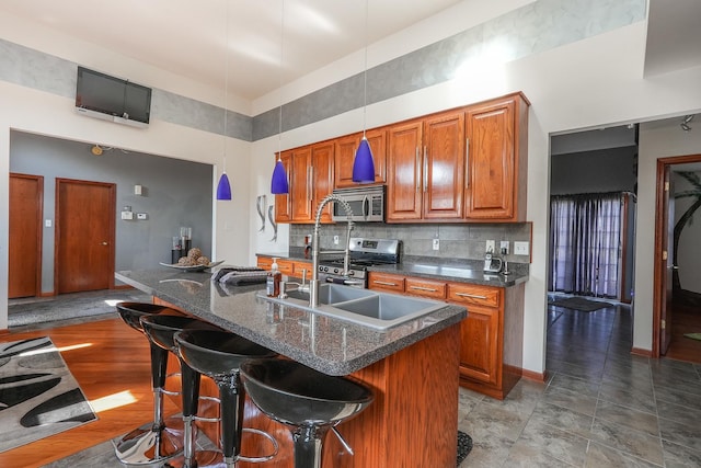 2069 Willow Brook Dr, Bourbonnais, IL 60914 - kitchen featuring appliances with stainless steel finishes, brown cabinets, decorative backsplash, a kitchen bar, and a towering ceiling