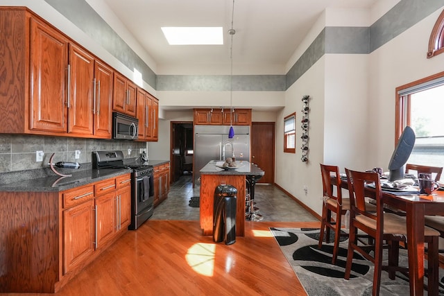 2069 Willow Brook Dr, Bourbonnais, IL 60914 - kitchen featuring appliances with stainless steel finishes, a skylight, plenty of natural light, and brown cabinets