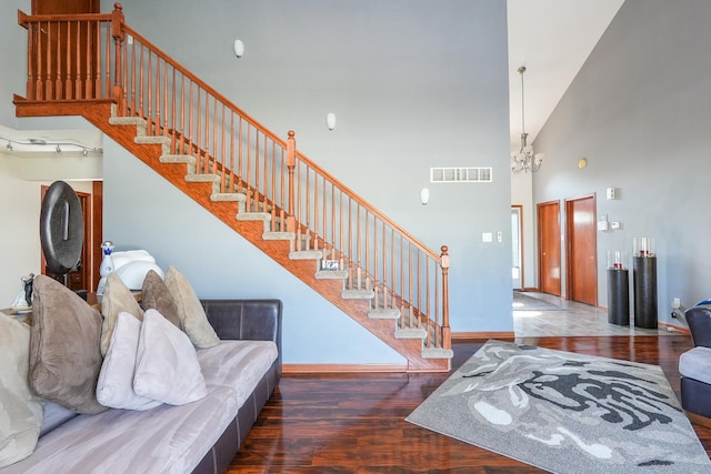 2069 Willow Brook Dr, Bourbonnais, IL 60914 - living room featuring stairs, wood finished floors, a towering ceiling, and a chandelier