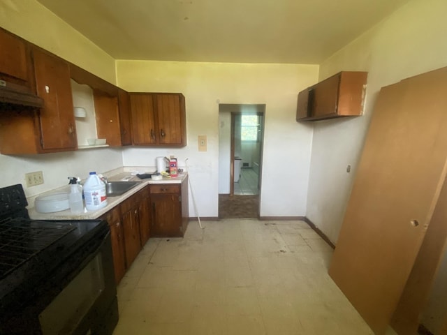 217-219 Mulvain St, Durand, IL 61024 - kitchen with black electric range, light floors, light countertops, and brown cabinets