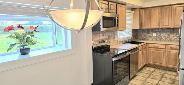 1607 Warwick Ln, Schaumburg, IL 60193 - kitchen featuring appliances with stainless steel finishes, decorative backsplash, light countertops, and healthy amount of natural light