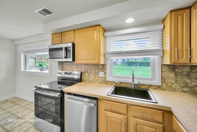 1607 Warwick Ln, Schaumburg, IL 60193 - kitchen featuring appliances with stainless steel finishes, light countertops, tasteful backsplash, and light brown cabinetry