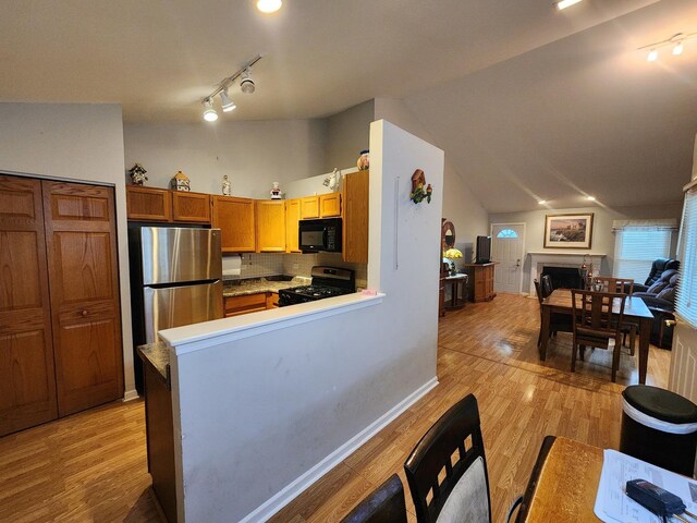 1036 Georgian Pl, Bartlett, IL 60103 - kitchen featuring black appliances, open floor plan, track lighting, light wood-style flooring, and lofted ceiling