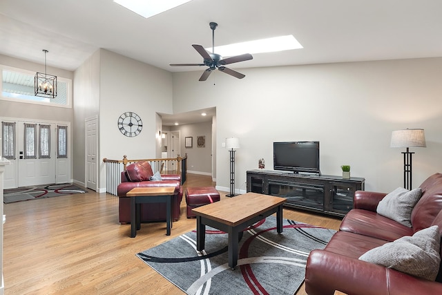 16243 Hummingbird Hill Dr, Orland Park, IL 60467 - living area featuring high vaulted ceiling, light wood-style floors, a chandelier, ceiling fan, and a skylight