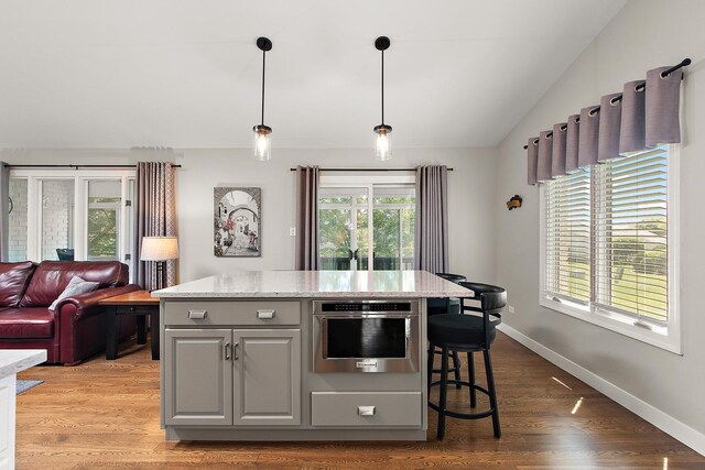 16243 Hummingbird Hill Dr, Orland Park, IL 60467 - kitchen featuring vaulted ceiling, gray cabinetry, a center island, light stone counters, and pendant lighting